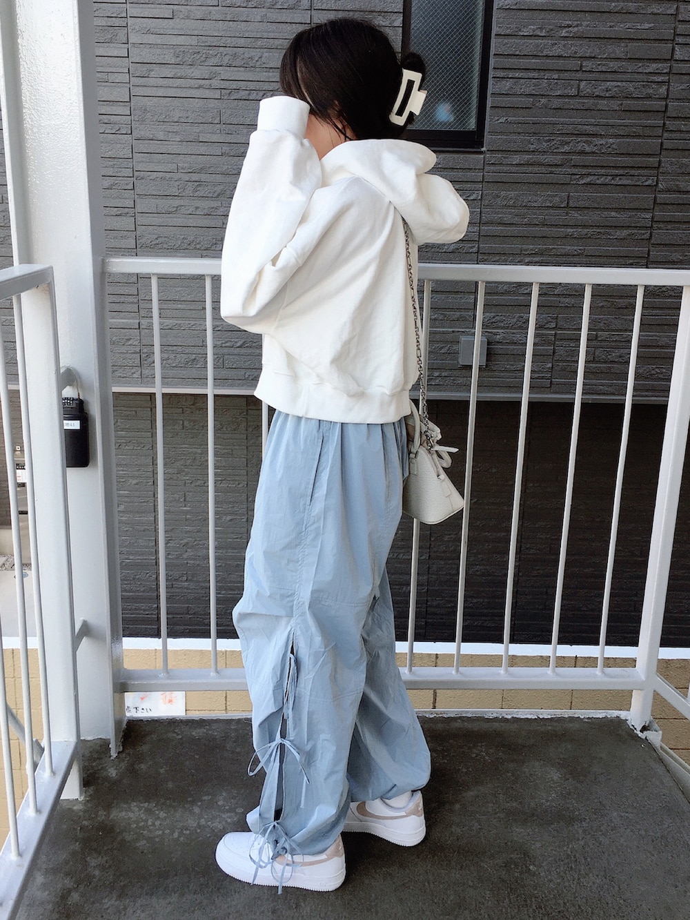 ホワイト系のスウェット、ブルー系のその他パンツ、ベージュ系のスニーカーを着用したレディースの春コーディネートの2枚目の写真