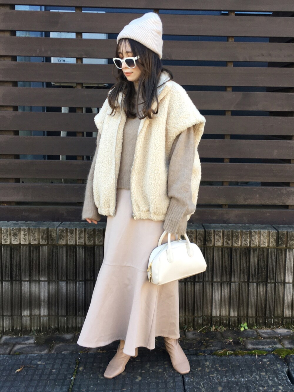 ベージュ系のトップス、ベージュ系のニット/セーター、ホワイト系のショルダーバッグを着用したレディースの秋コーディネートの2枚目の写真