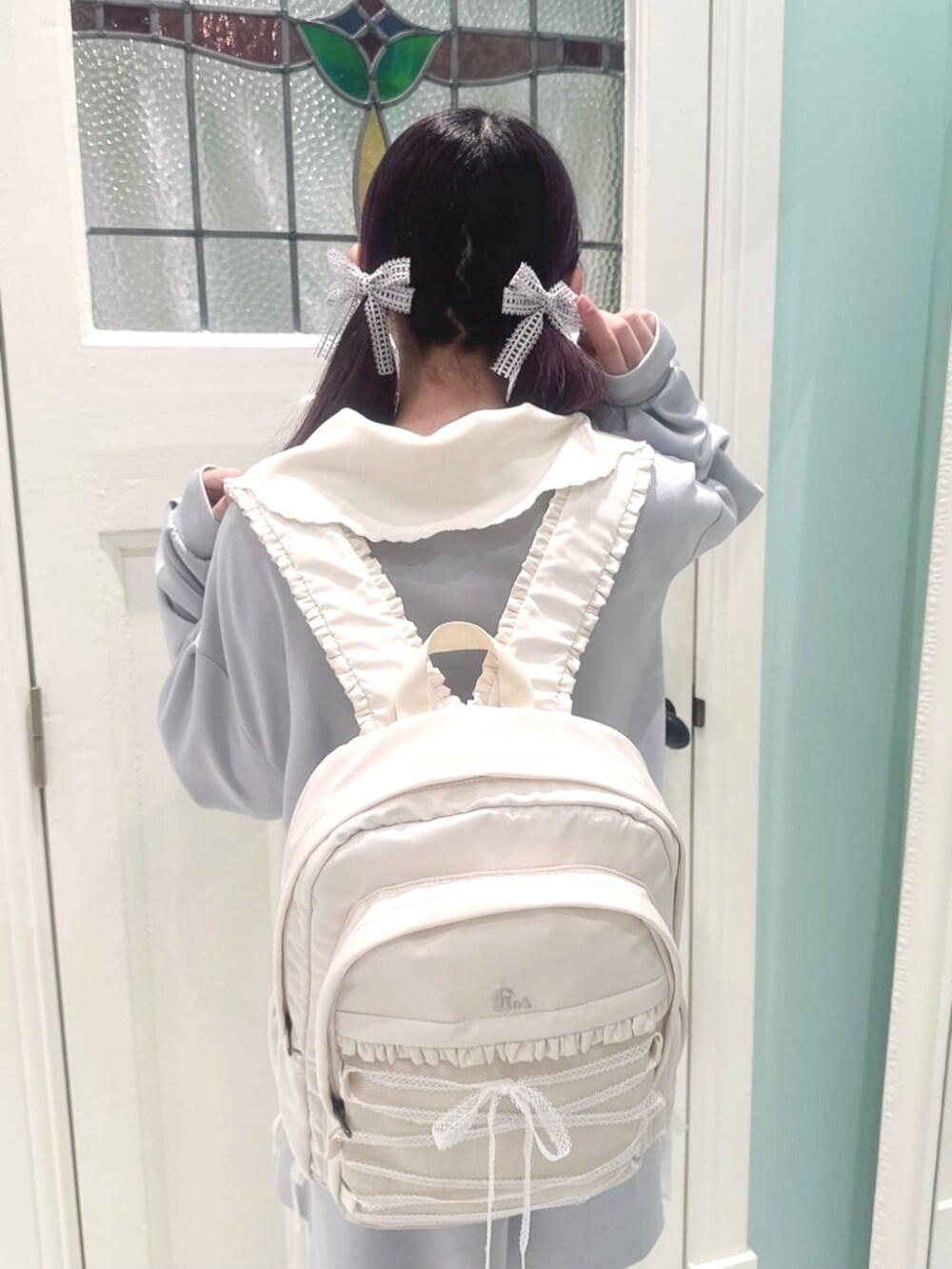 グレー系のスウェット、ホワイト系のバックパック/リュック、ブルー系のスカートを着用したレディースの春コーディネートの4枚目の写真