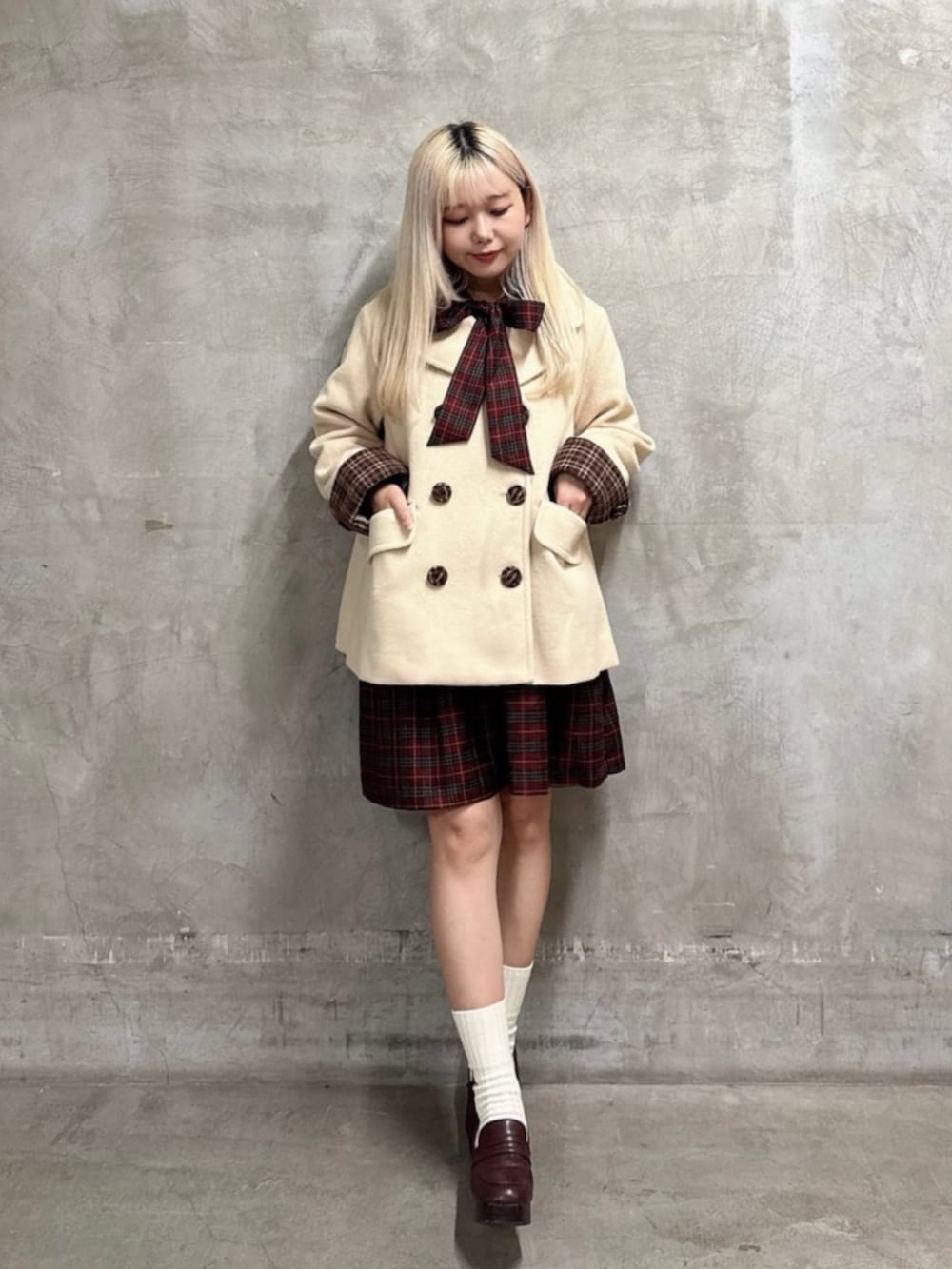 ベージュ系のピーコート、レッド系のワンピースを着用したレディースの秋コーディネートの2枚目の写真