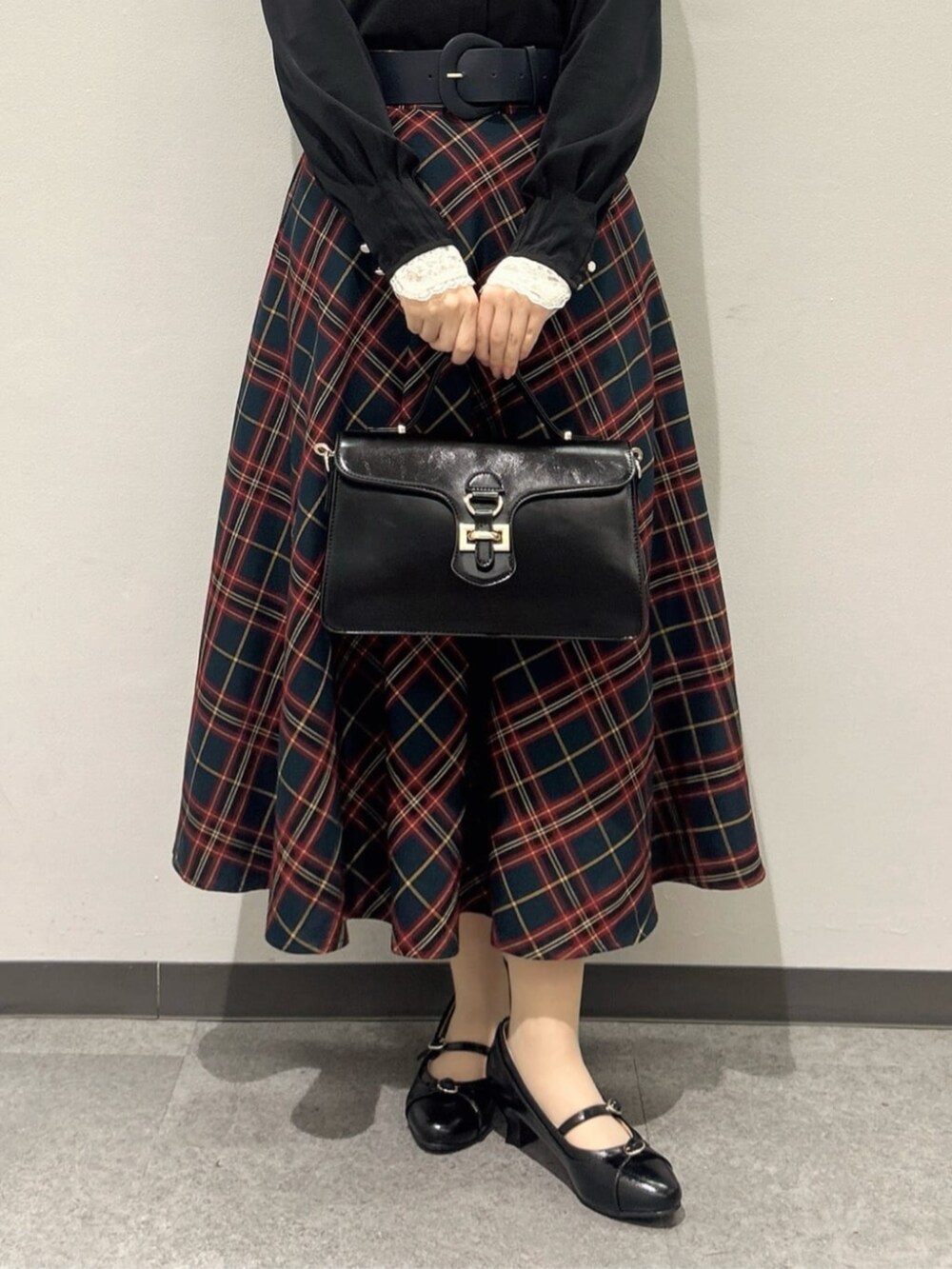 ブラック系のハンドバッグ、ブラック系のパンプス、ブラック系のシャツ/ブラウスを着用したレディースの冬コーディネートの3枚目の写真
