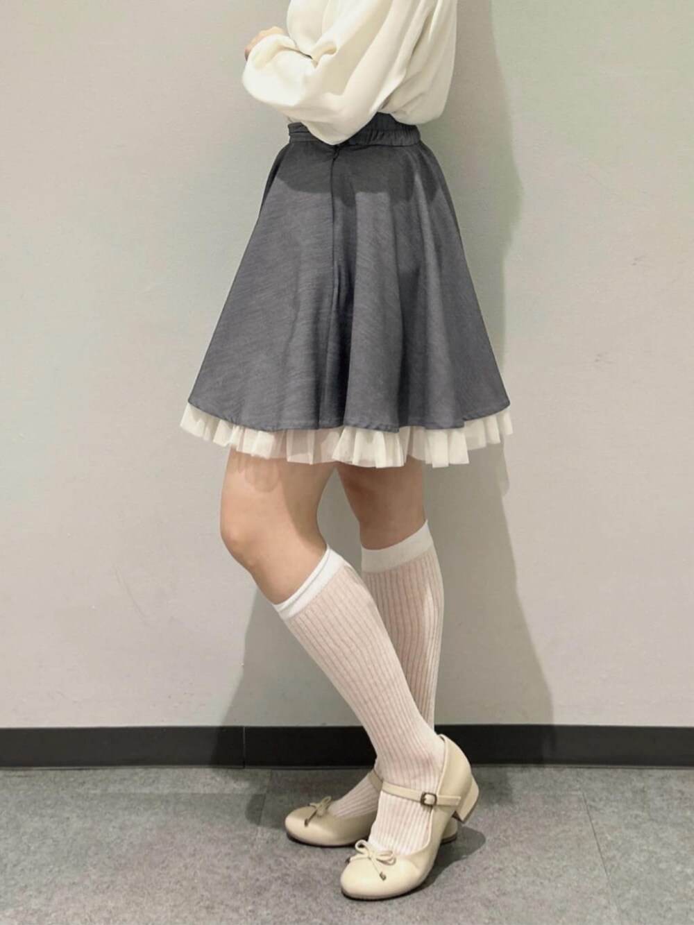 ホワイト系のカーディガン/ボレロ、ベージュ系のパンプス、ホワイト系のシャツ/ブラウスを着用したレディースの冬コーディネートの3枚目の写真