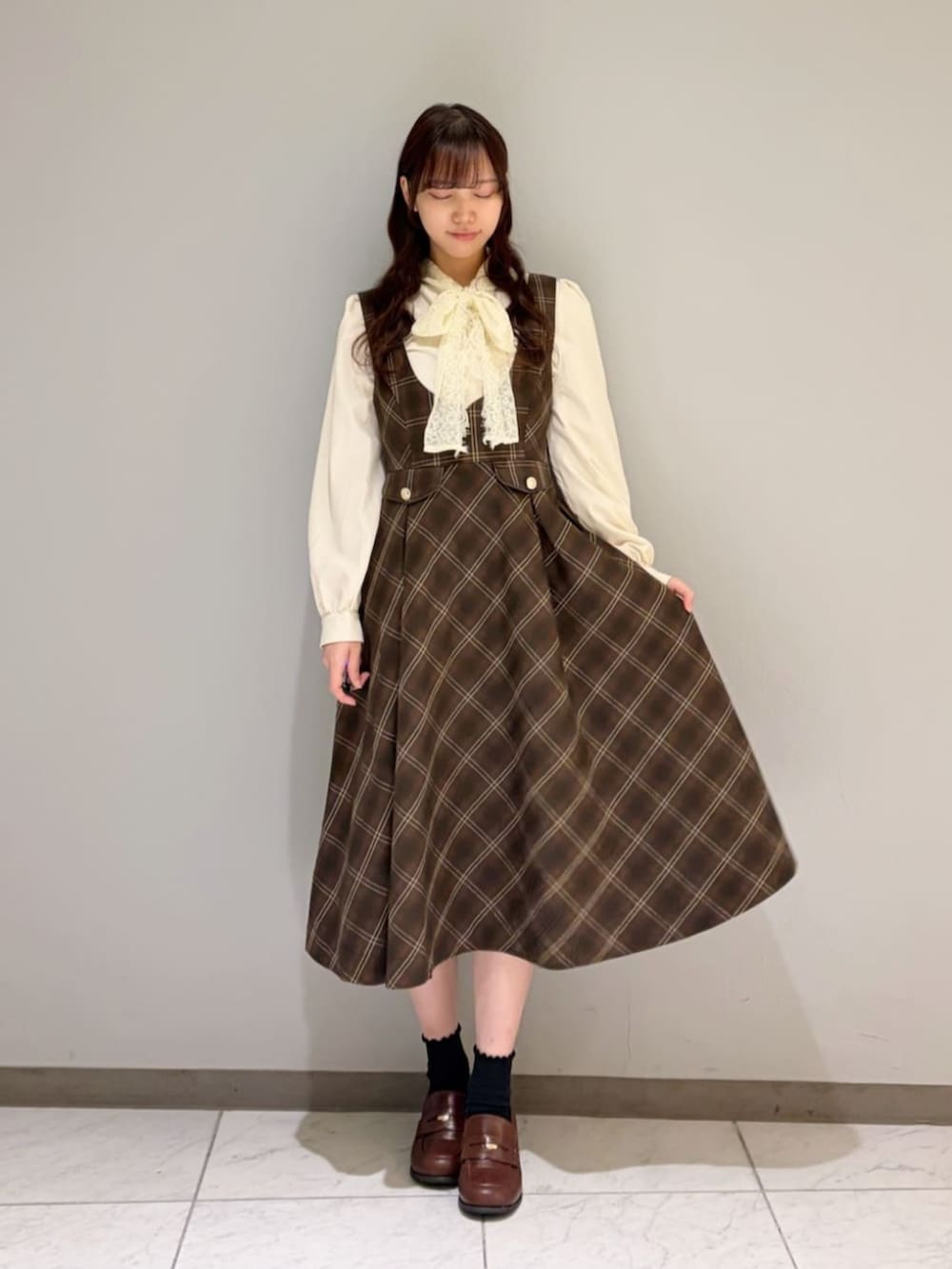 ブラウン系のローファー、ホワイト系のシャツ/ブラウス、ブラウン系のピーコートを着用したレディースの冬コーディネートの2枚目の写真