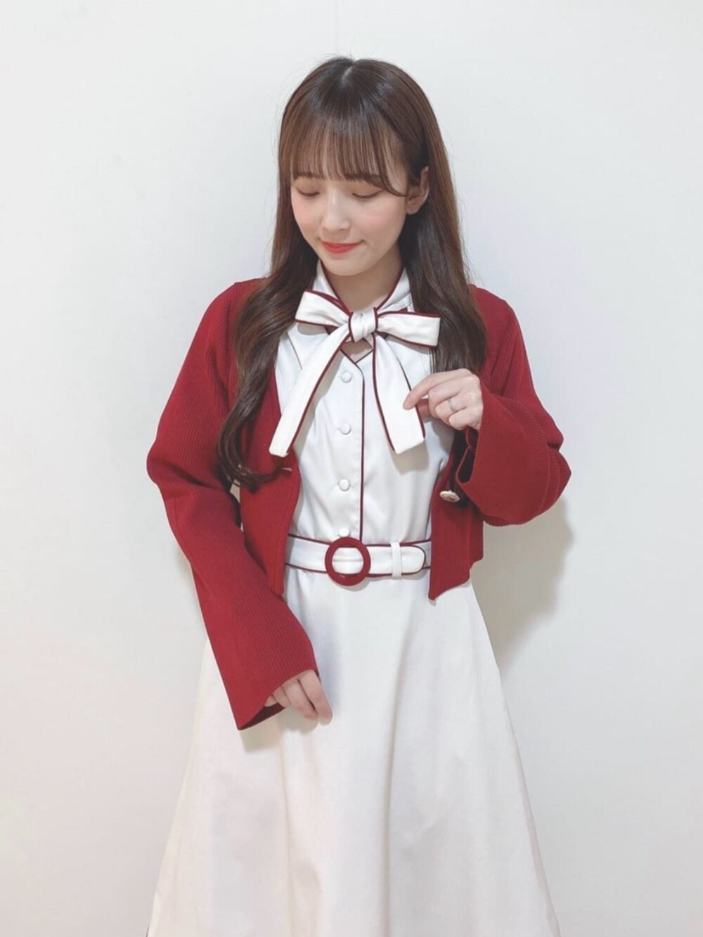 レッド系のカーディガン/ボレロ、ホワイト系のパンプス、ホワイト系のハンドバッグを着用したレディースの春コーディネートの2枚目の写真