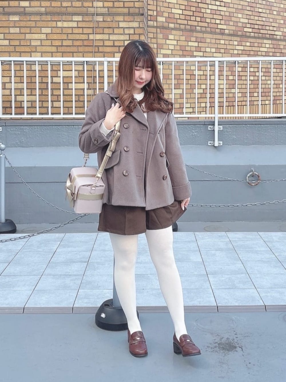 ブラウン系のローファー、ブラウン系のその他パンツ、ブラウン系のピーコートを着用したレディースの秋コーディネートの2枚目の写真