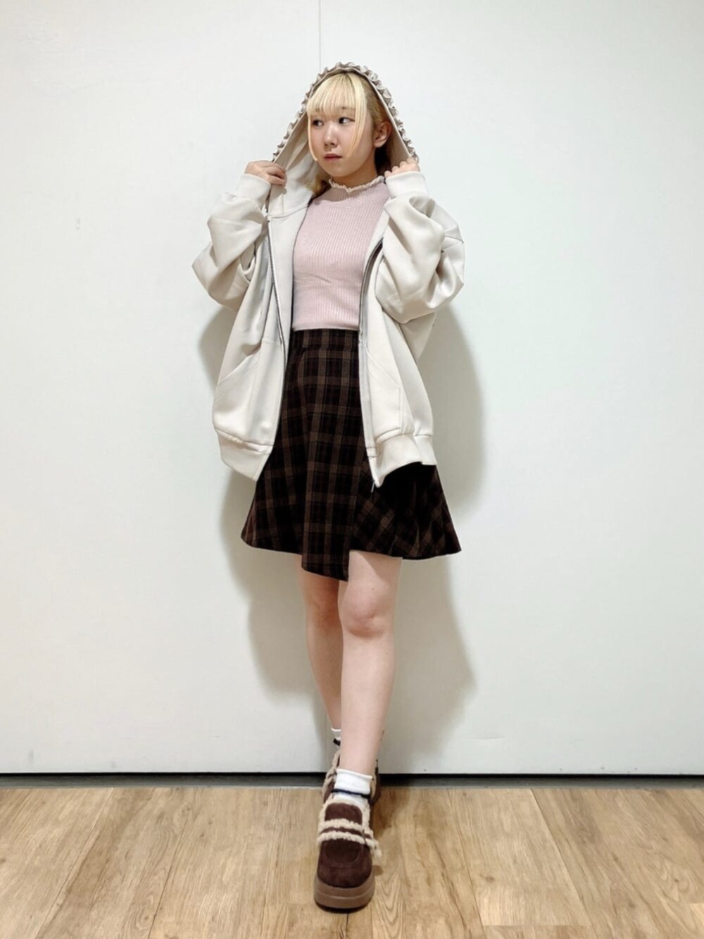 ピンク系のニット/セーター、ブラウン系のスカート、ブラウン系のモカシン/デッキシューズを着用したレディースの秋コーディネートの2枚目の写真