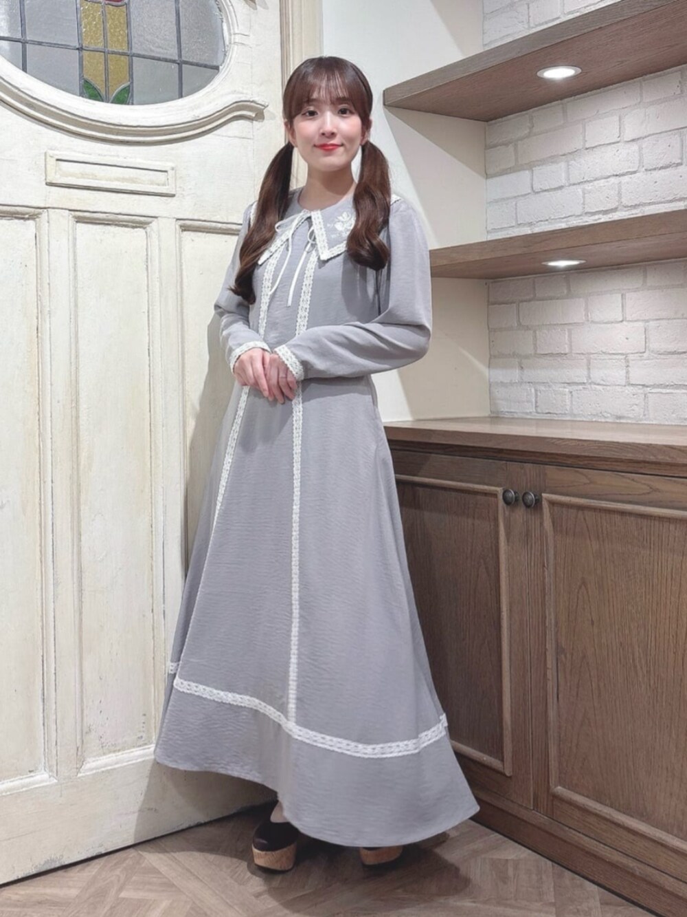 グレー系のワンピース、ブラウン系のパンプスを着用したレディースの秋コーディネートの2枚目の写真