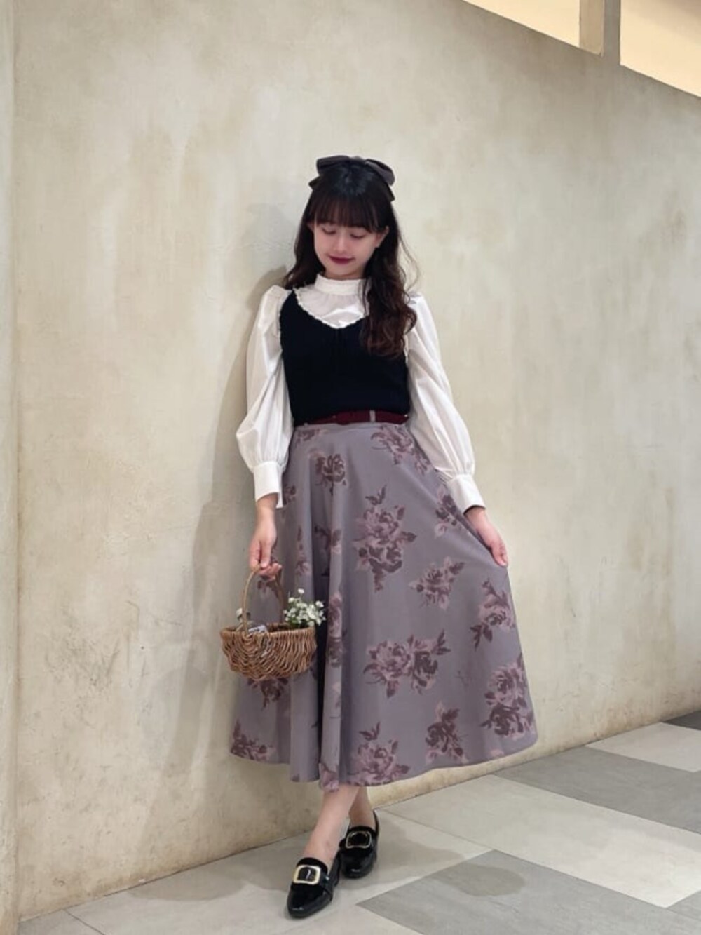 ブラック系のベスト、ホワイト系のシャツ/ブラウス、レッド系のスカートを着用したレディースの秋コーディネートの2枚目の写真