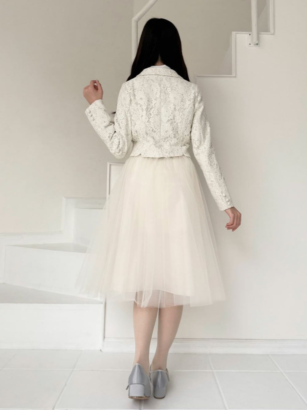 ホワイト系のシャツ/ブラウス、ホワイト系のスカート、グレー系のパンプスを着用したレディースの冬コーディネートの3枚目の写真