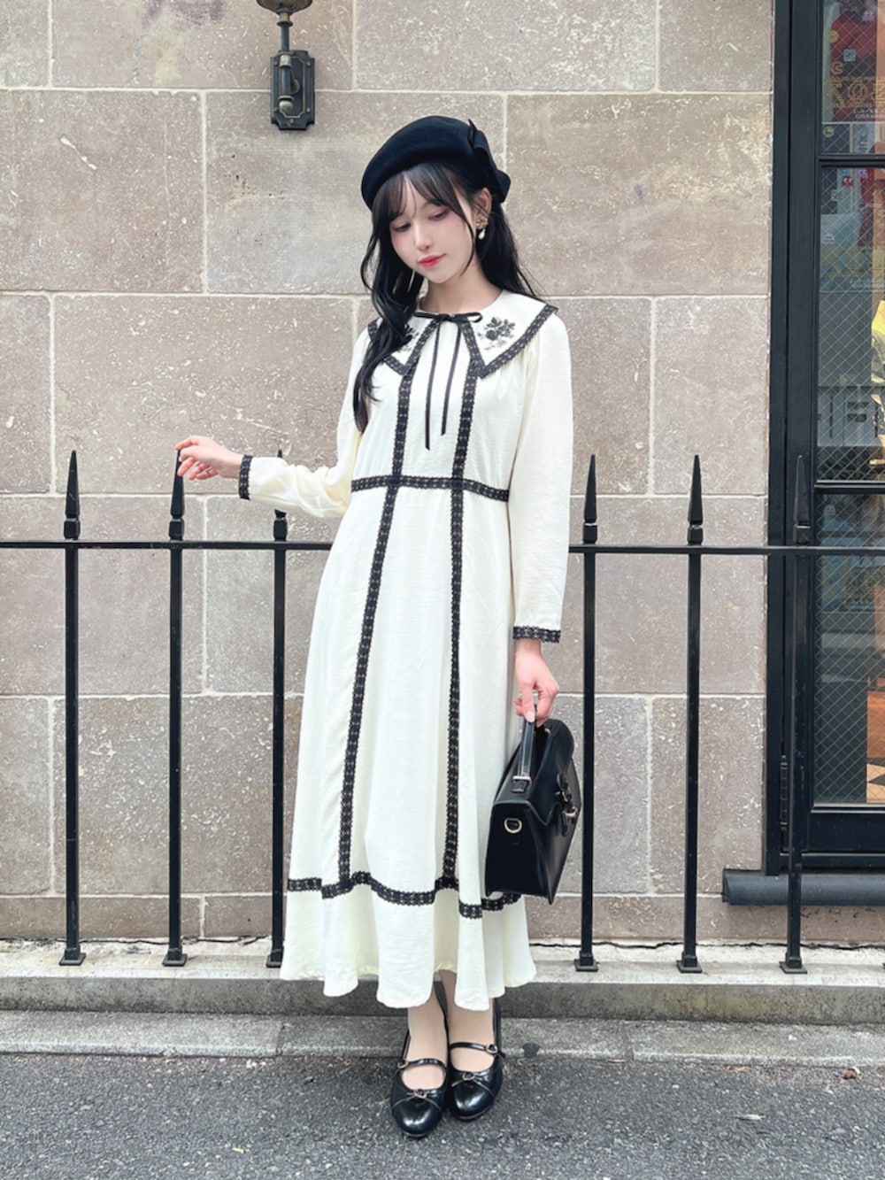 ベージュ系のワンピース、ブラック系のパンプスを着用したレディースの夏コーディネートの2枚目の写真