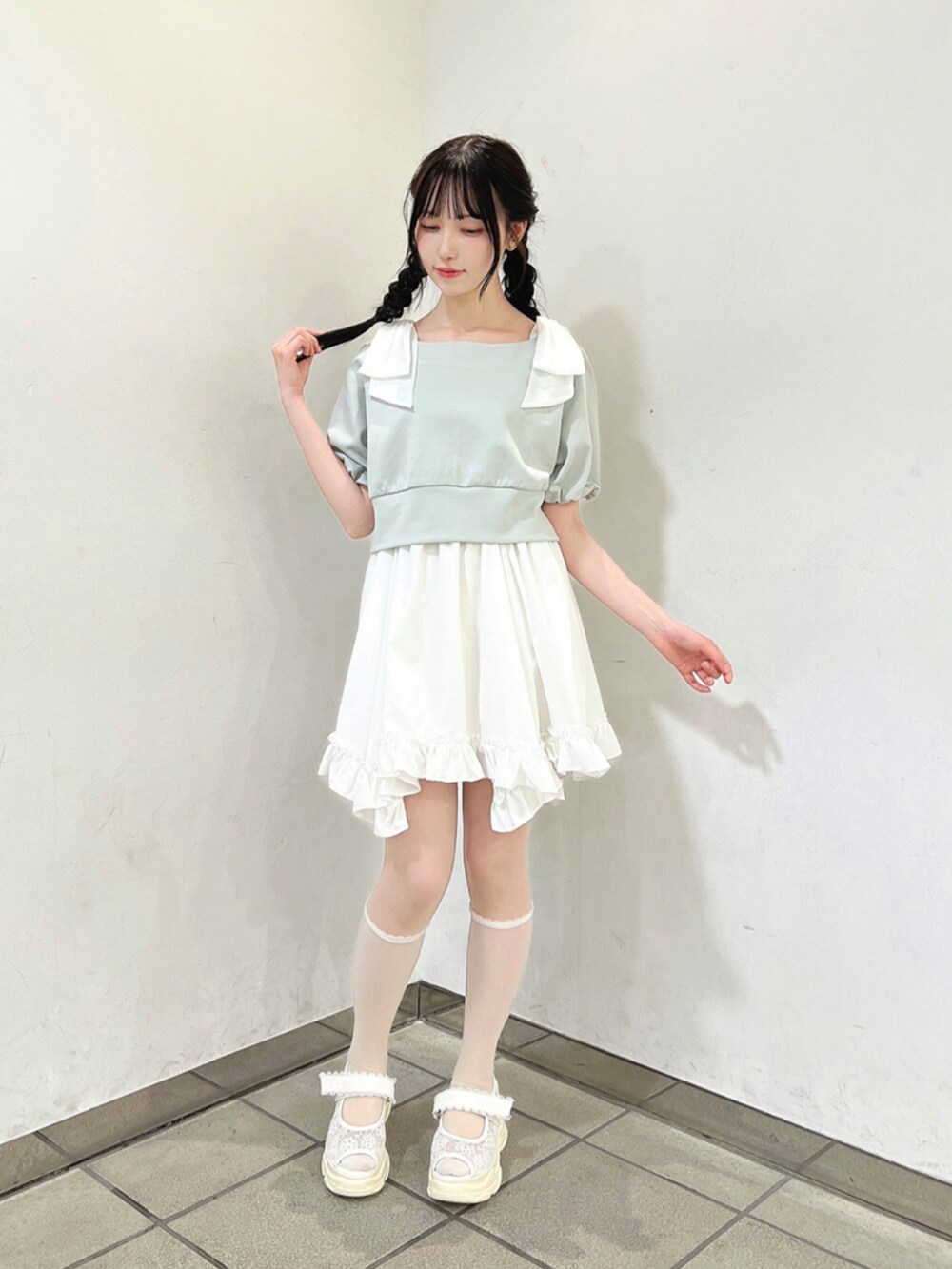 ホワイト系のスカート、ホワイト系のサンダル、グレー系のTシャツ/カットソーを着用したレディースの春コーディネートの2枚目の写真