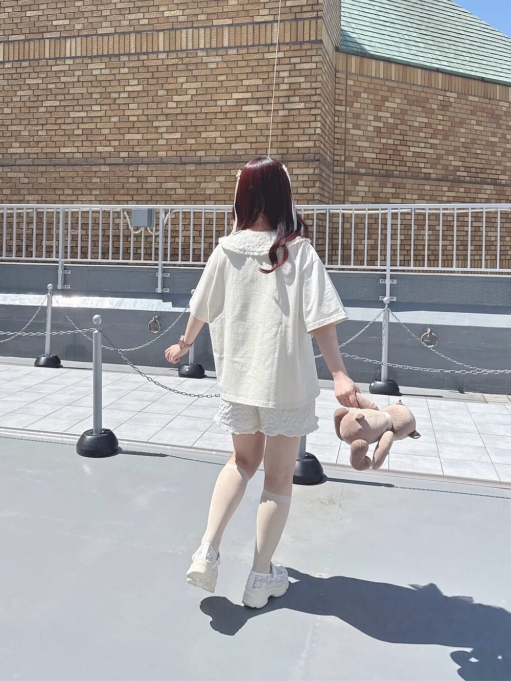 ホワイト系のサンダル、ホワイト系のセットアップ、ホワイト系のTシャツ/カットソーを着用したレディースの春コーディネートの4枚目の写真