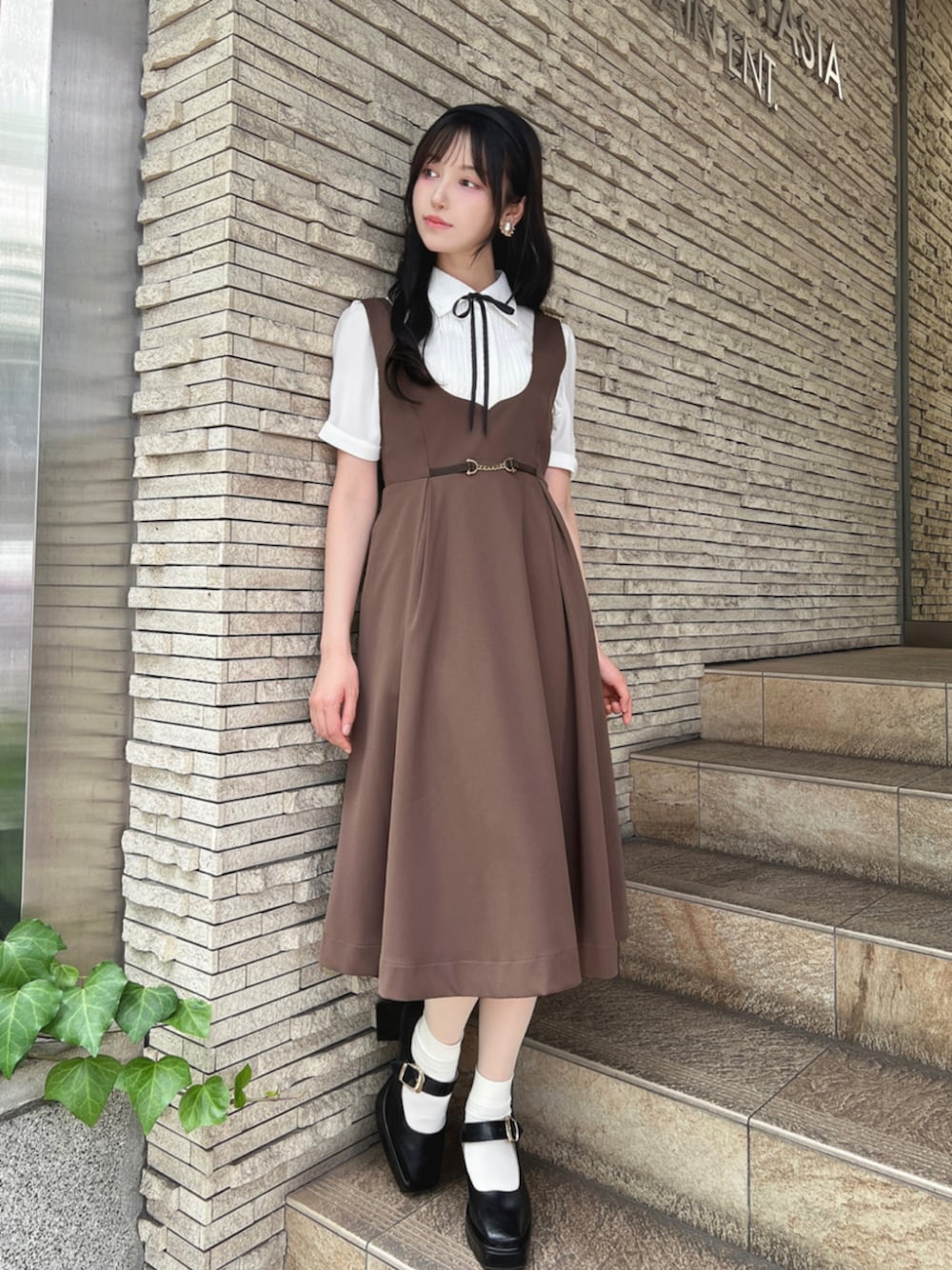 ホワイト系のシャツ/ブラウス、ブラック系のパンプス、ブラウン系のジャンパースカートを着用したレディースの夏コーディネートの2枚目の写真