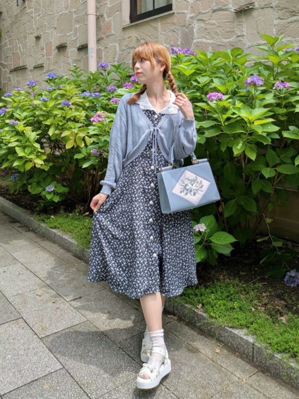 ブラック系のワンピース、ホワイト系のサンダル、ブルー系のトートバッグを着用したレディースの夏コーディネートの2枚目の写真