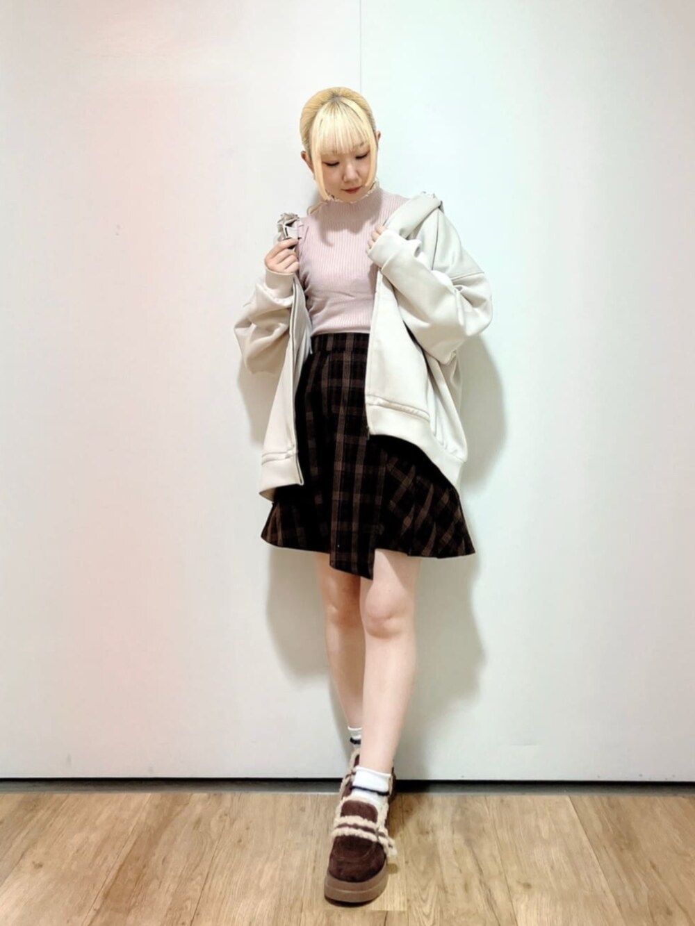 ピンク系のニット/セーター、ブラウン系のスカート、ブラウン系のモカシン/デッキシューズを着用したレディースの秋コーディネートの3枚目の写真