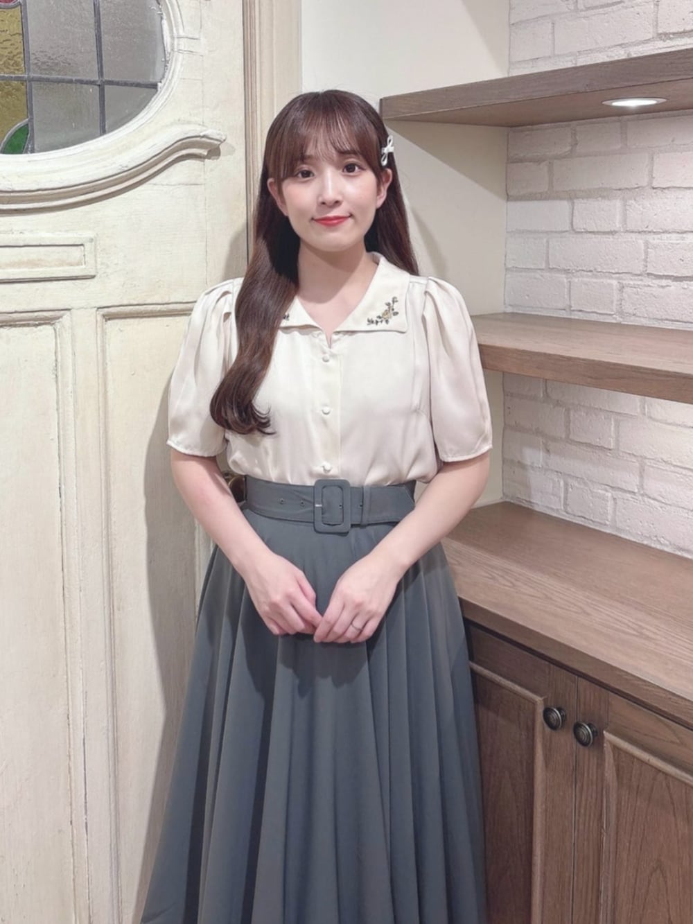 グリーン系のスカート、ブラウン系のパンプス、ベージュ系のシャツ/ブラウスを着用したレディースの秋コーディネートの3枚目の写真