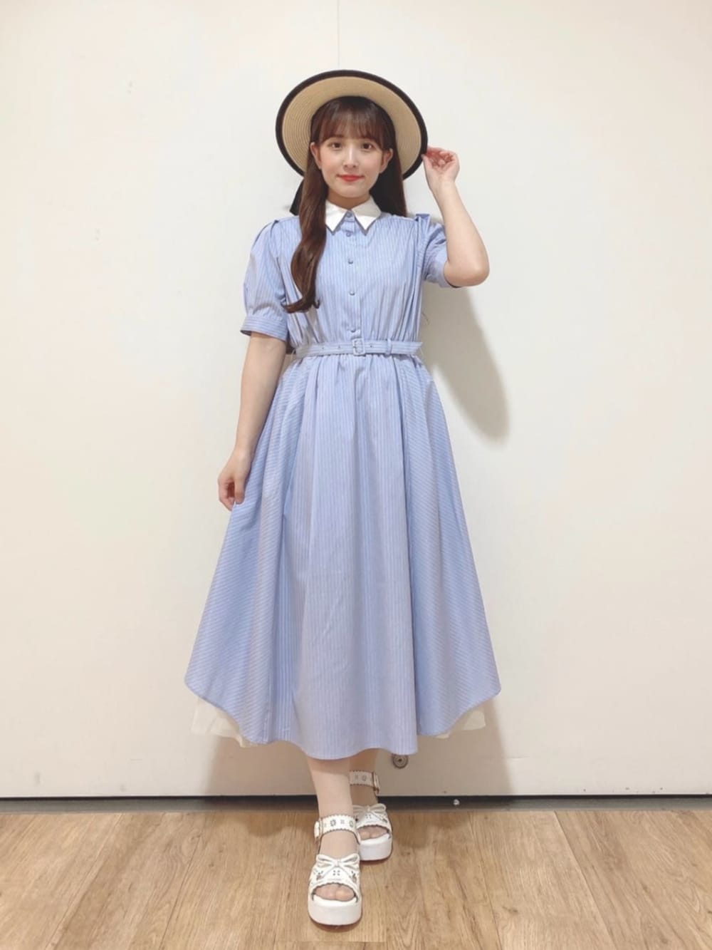 ブルー系のシャツワンピース、ホワイト系のサンダル、ベージュ系のハットを着用したレディースの夏コーディネートの2枚目の写真