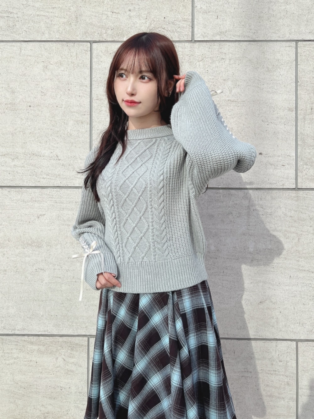 ブラウン系のブーツ、ブルー系のスカート、グレー系のニット/セーターを着用したレディースの冬コーディネートの2枚目の写真