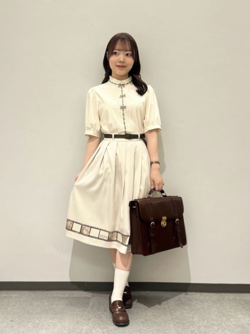 ブラウン系のセットアップ、ブラウン系のローファー、ブラウン系のハンドバッグを着用したレディースの春コーディネートの2枚目の写真