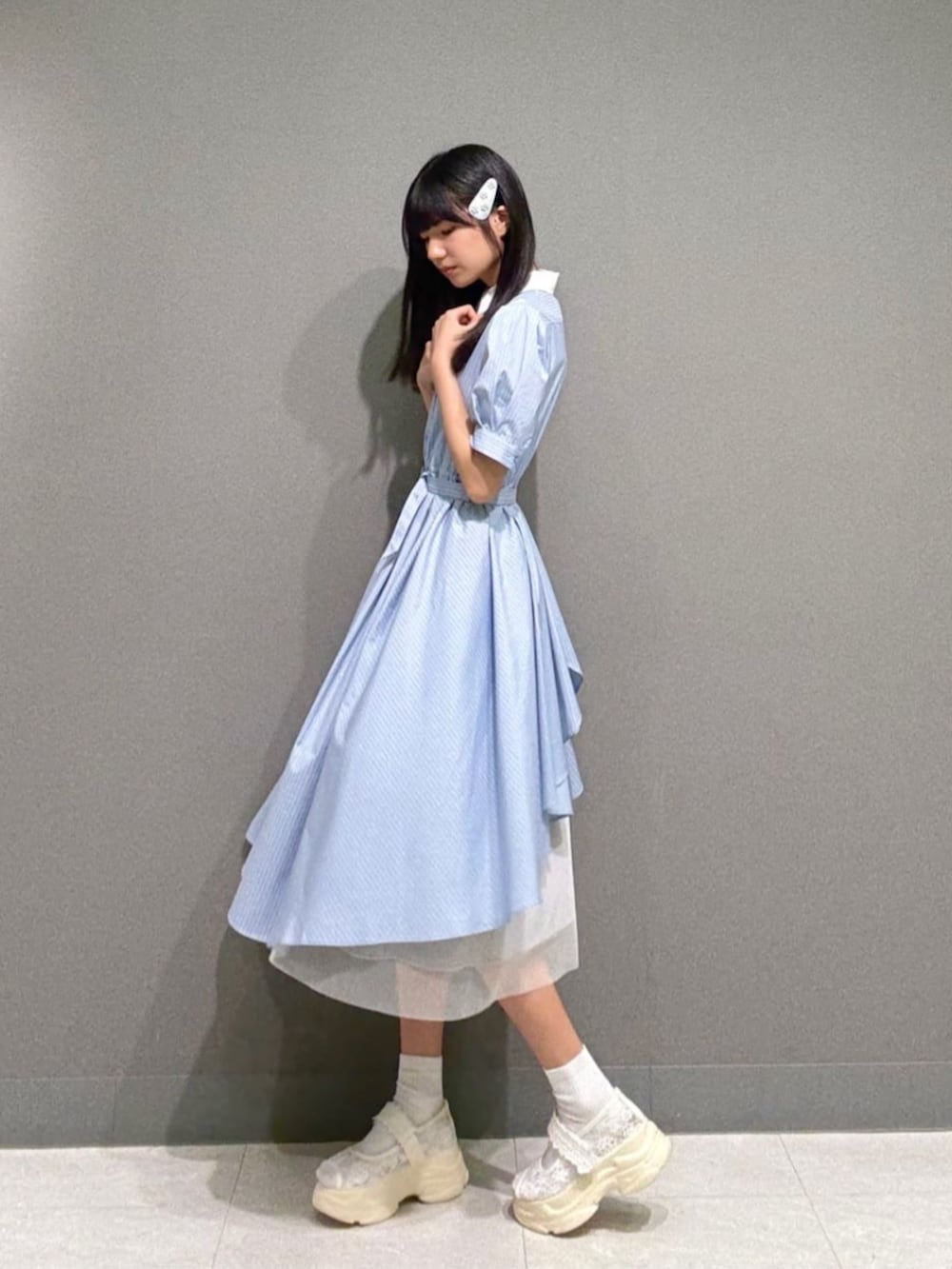 ホワイト系のサンダル、ブルー系のシャツワンピース、グレー系のヘアピンを着用したレディースの夏コーディネートの2枚目の写真