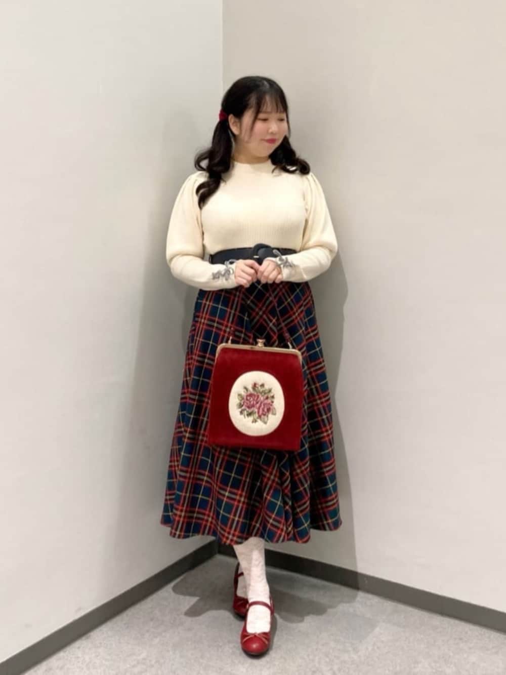 レッド系のバレエシューズ、レッド系のハンドバッグ、ブラック系のスカートを着用したレディースの冬コーディネートの2枚目の写真