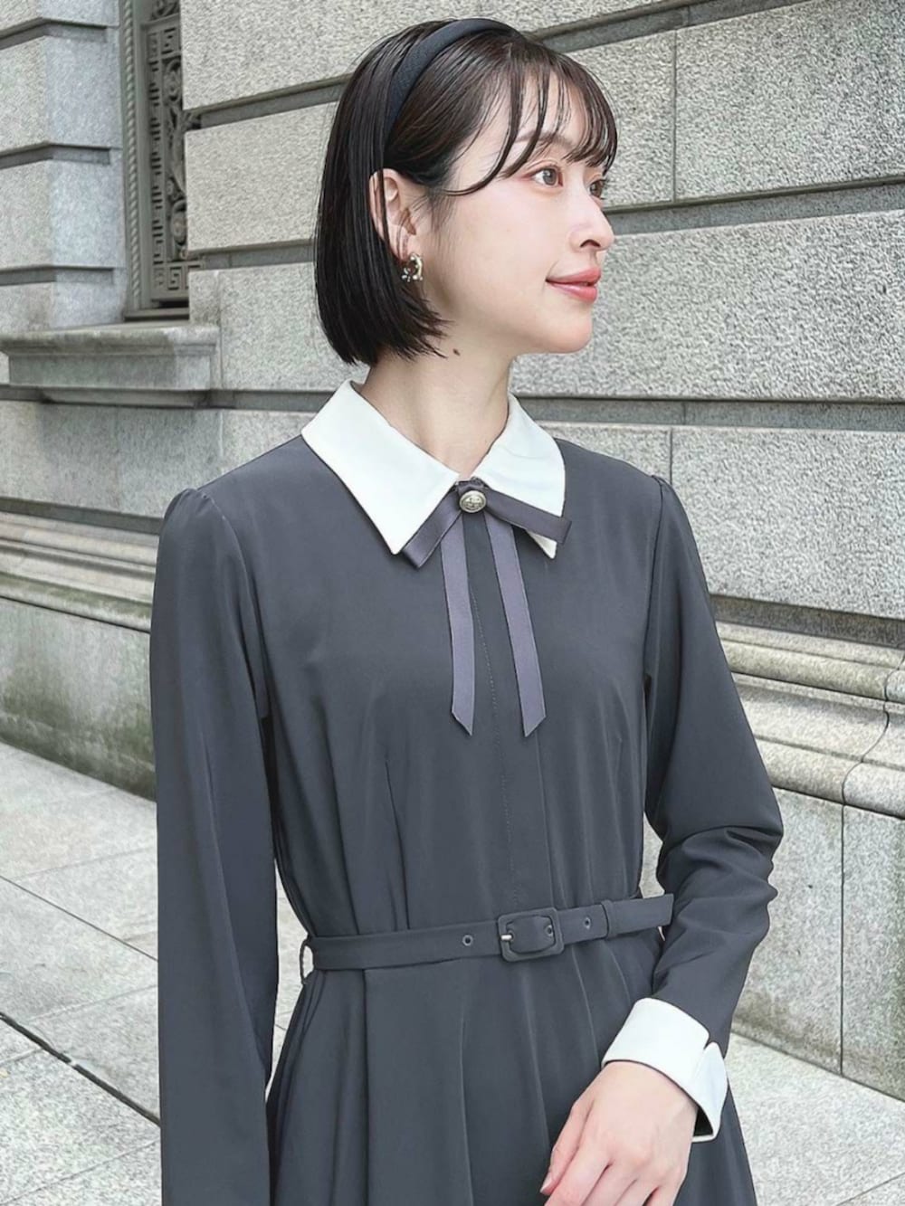 グレー系のワンピース、ブラック系のパンプスを着用したレディースの秋コーディネートの2枚目の写真