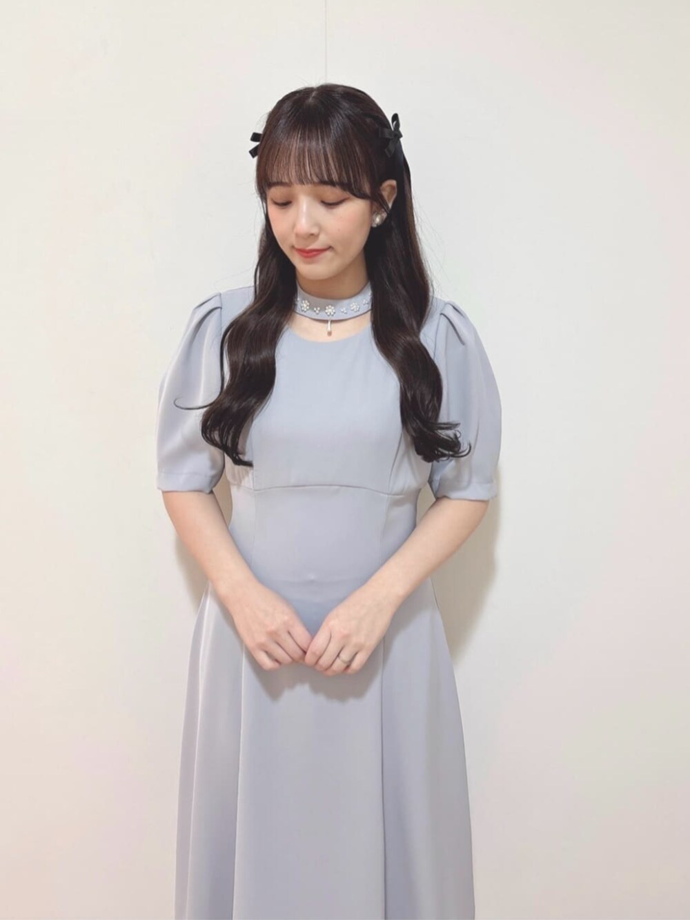 シルバー系のパンプス、ブルー系のドレスを着用したレディースの冬コーディネートの2枚目の写真