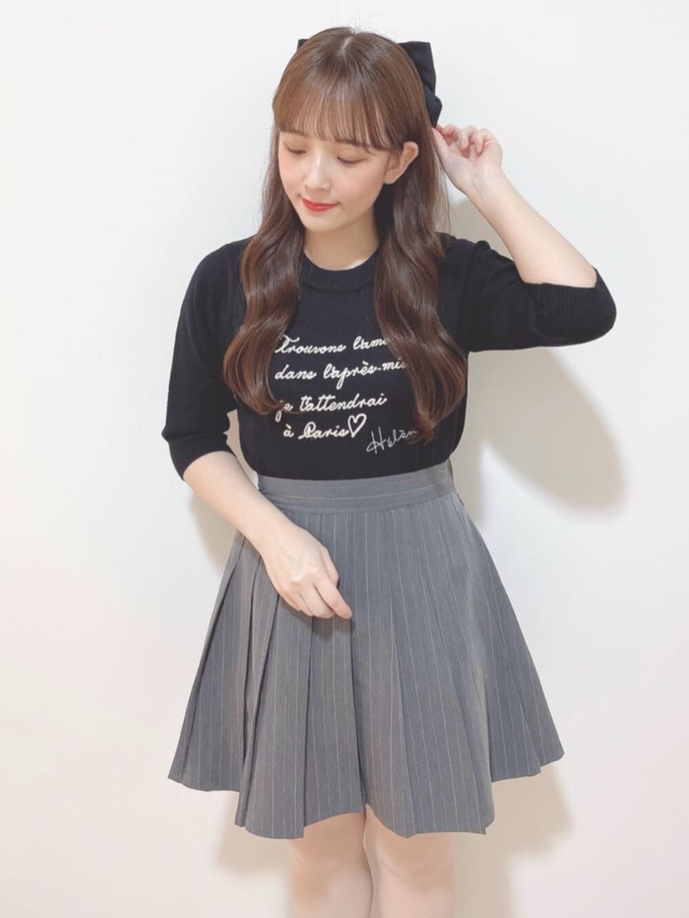 グレー系のスカート、ブラック系のハンドバッグ、ブラック系のローファーを着用したレディースの秋コーディネートの4枚目の写真