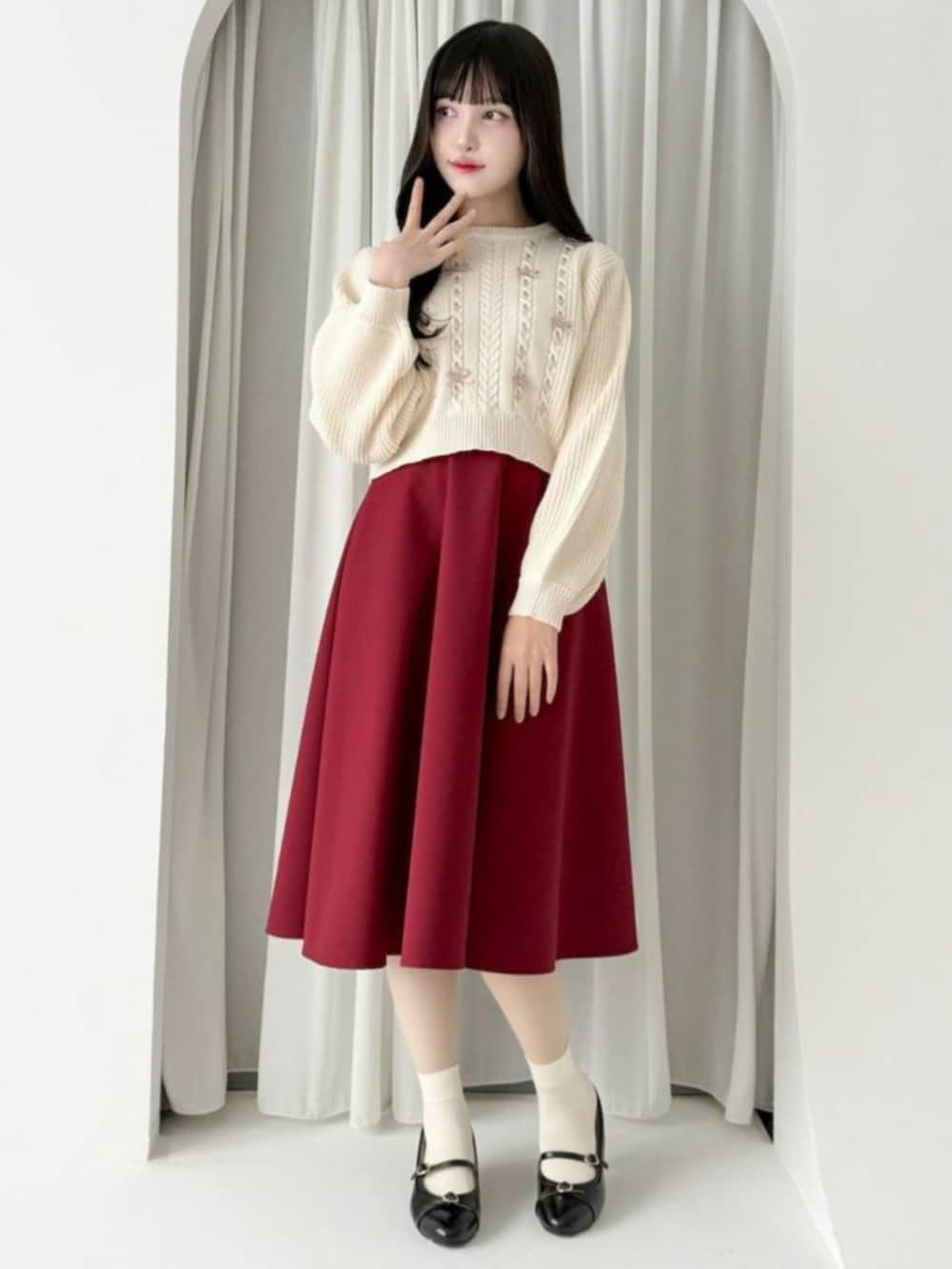 ブラック系のパンプス、レッド系のスカート、ホワイト系のニット/セーターを着用したレディースの秋コーディネートの2枚目の写真