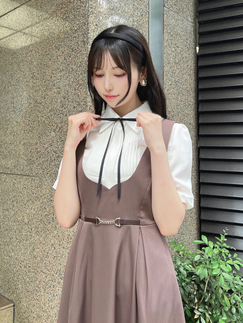 ホワイト系のシャツ/ブラウス、ブラック系のパンプス、ブラウン系のジャンパースカートを着用したレディースの夏コーディネートの3枚目の写真
