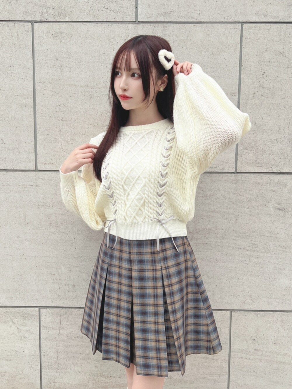 ベージュ系のスカート、ホワイト系のニット/セーター、ブラウン系のローファーを着用したレディースの秋コーディネートの2枚目の写真