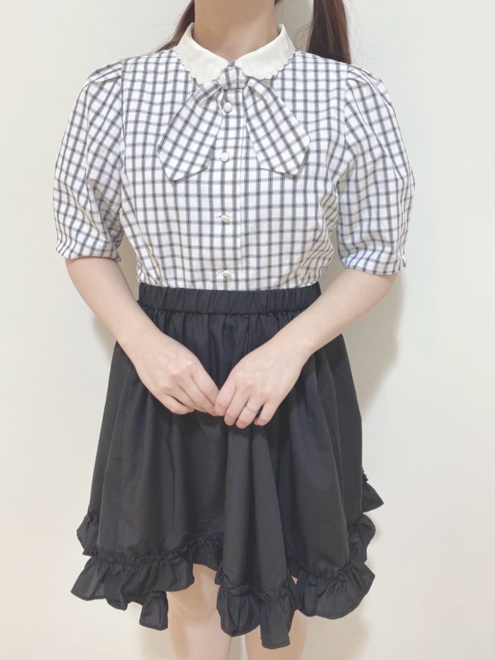 ホワイト系のシャツ/ブラウス、ブラック系のスカート、ブラック系のハンドバッグを着用したレディースの春コーディネートの3枚目の写真