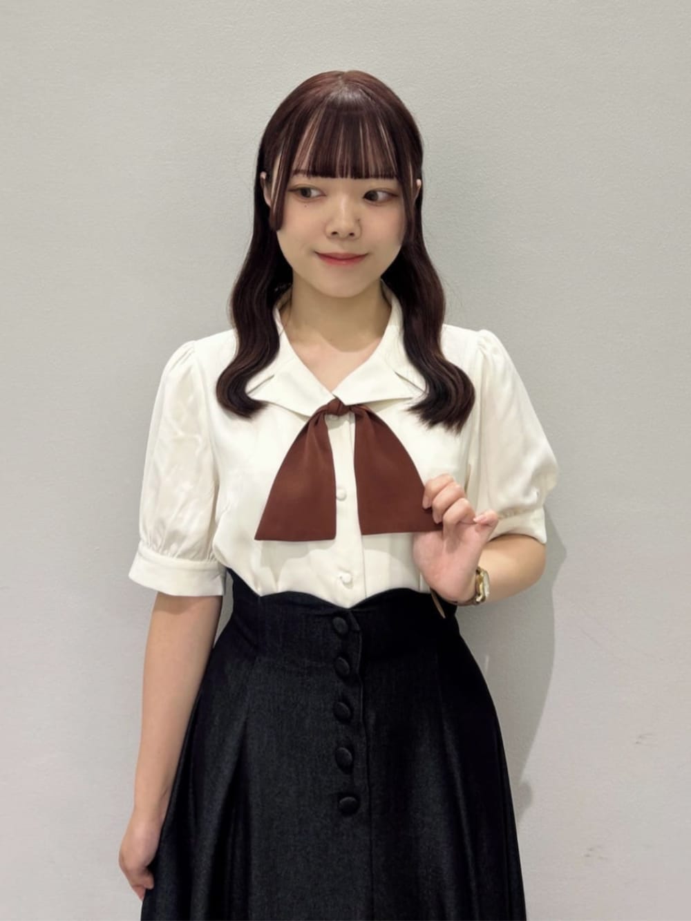 ブラウン系のローファー、ブラック系のデニムスカート、ホワイト系のシャツ/ブラウスを着用したレディースの秋コーディネートの3枚目の写真