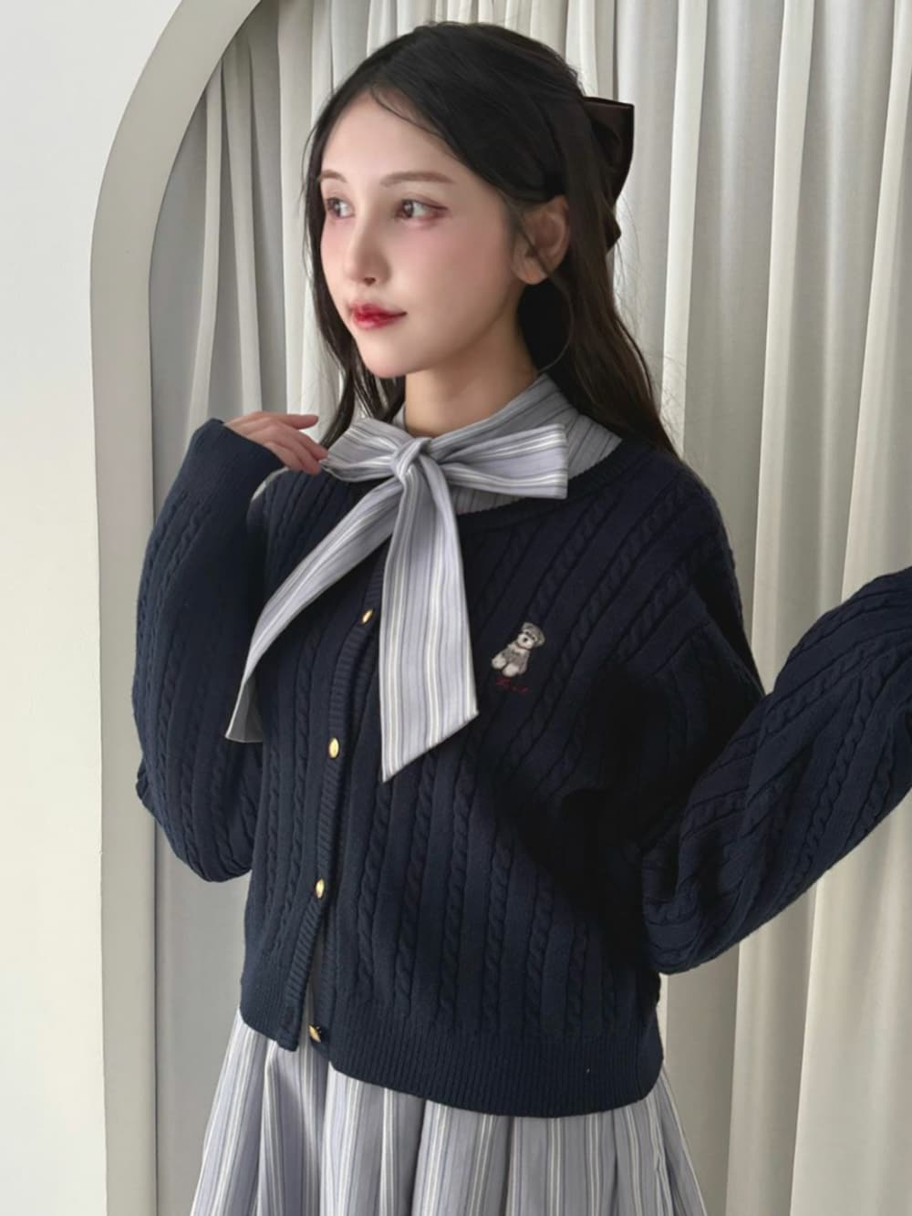 ブラック系のパンプス、ブルー系のカーディガン/ボレロを着用したレディースの冬コーディネートの3枚目の写真