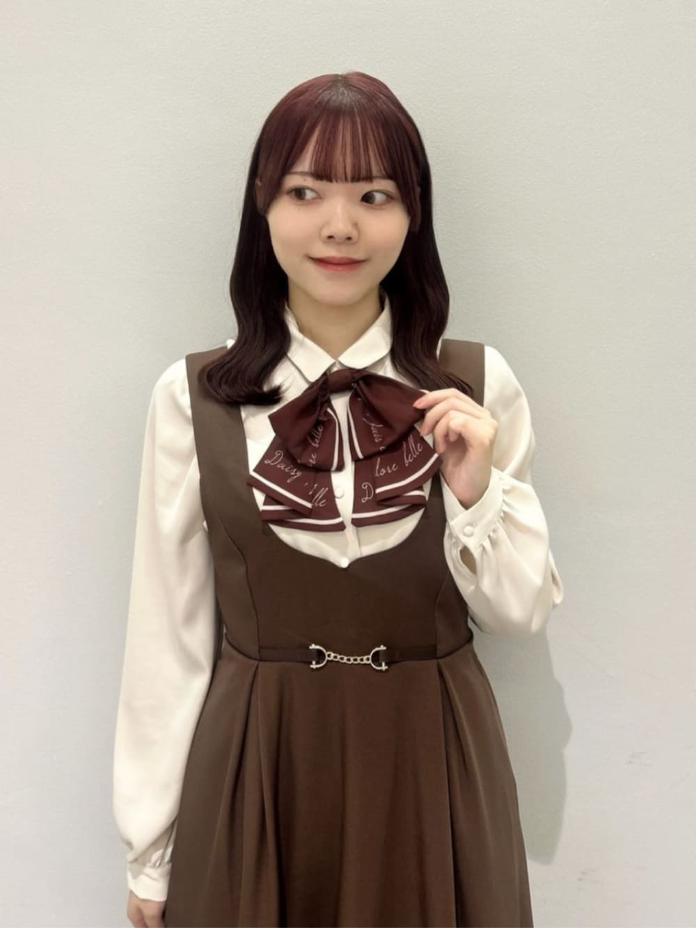 ブラウン系のジャンパースカート、ブラウン系のローファー、ブラウン系のショルダーバッグを着用したレディースの秋コーディネートの2枚目の写真