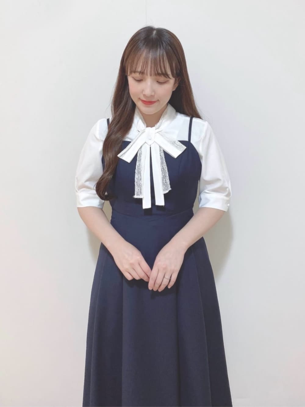 ホワイト系のパンプス、ブルー系のワンピース、ホワイト系のシャツ/ブラウスを着用したレディースの春コーディネートの2枚目の写真