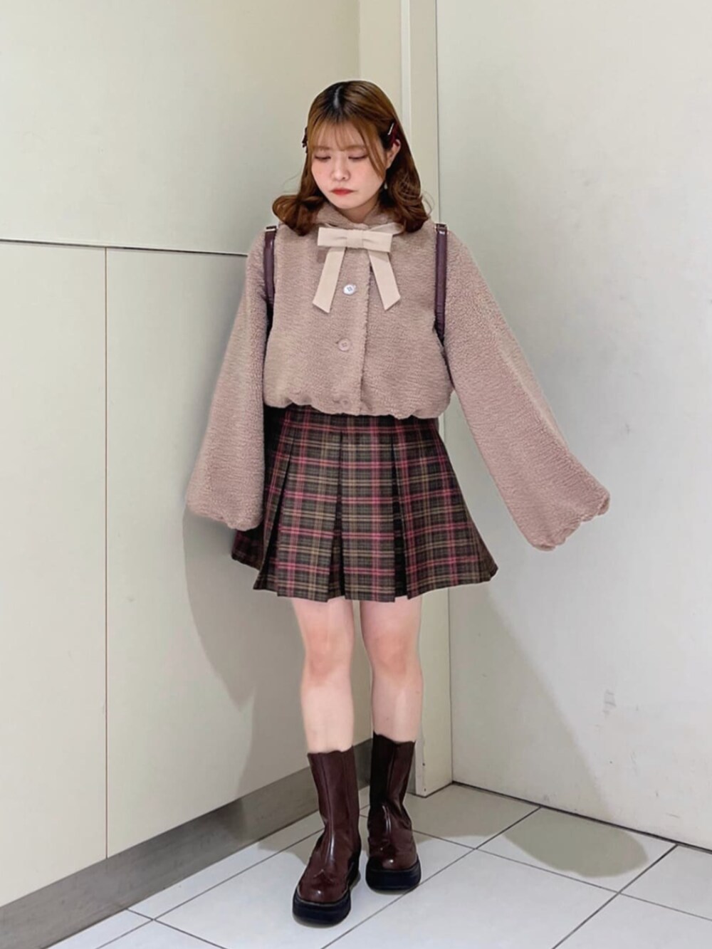 ピンク系のその他アウター、グリーン系のスカート、ブラウン系のブーツを着用したレディースの冬コーディネートの2枚目の写真