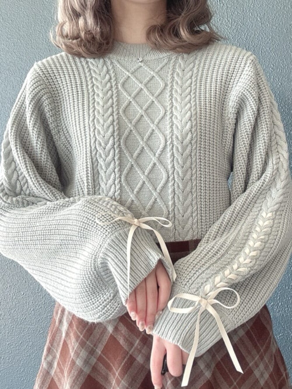 ブラウン系のパンプス、イエロー系のハンドバッグ、グレー系のニット/セーターを着用したレディースの冬コーディネートの2枚目の写真