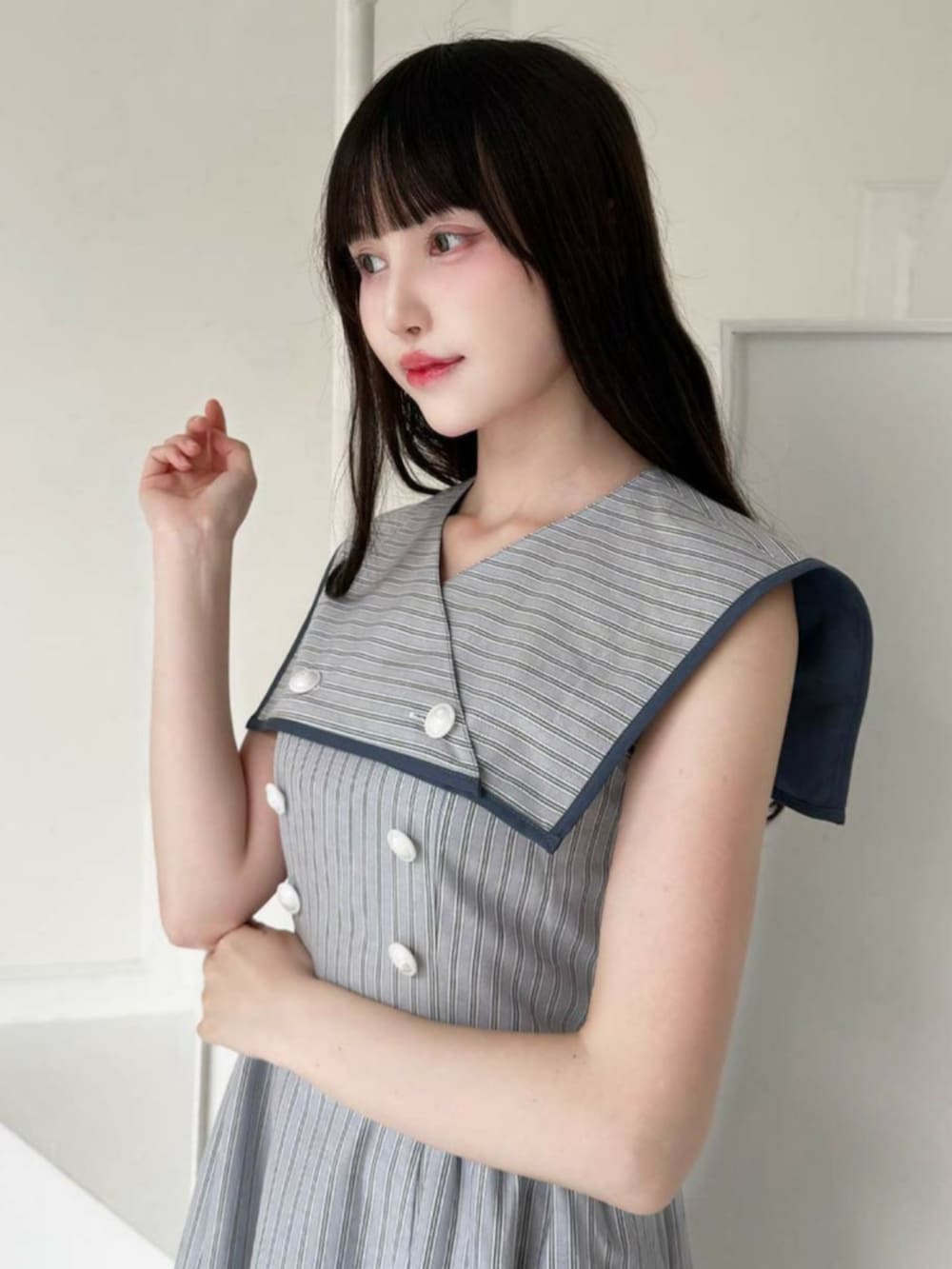 ブルー系のワンピース、ホワイト系のサンダル、ブルー系のショルダーバッグを着用したレディースの夏コーディネートの2枚目の写真