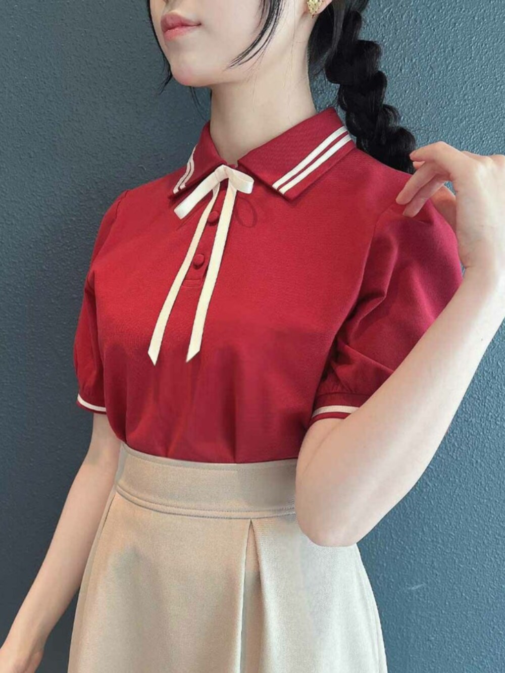 ベージュ系のスカート、レッド系のポロシャツを着用したレディースの春コーディネートの3枚目の写真