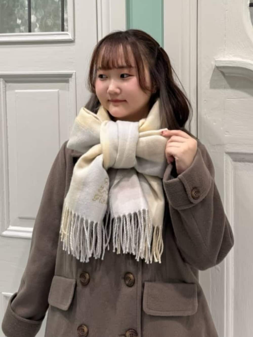 ブラック系のバレエシューズ、ブラウン系のピーコート、ブルー系のスカートを着用したレディースの冬コーディネートの3枚目の写真