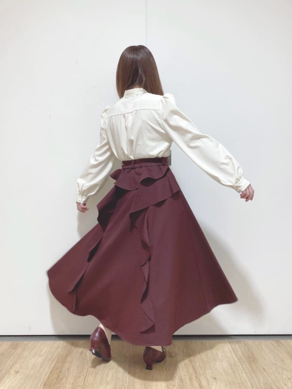 レッド系のパンプス、レッド系のハンドバッグ、ホワイト系のシャツ/ブラウスを着用したレディースの秋コーディネートの3枚目の写真