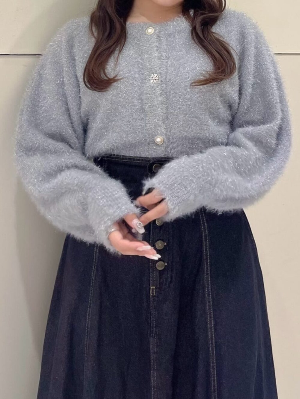 ブラック系のデニムスカート、ブラック系のパンプス、グレー系のカーディガン/ボレロを着用したレディースの秋コーディネートの3枚目の写真