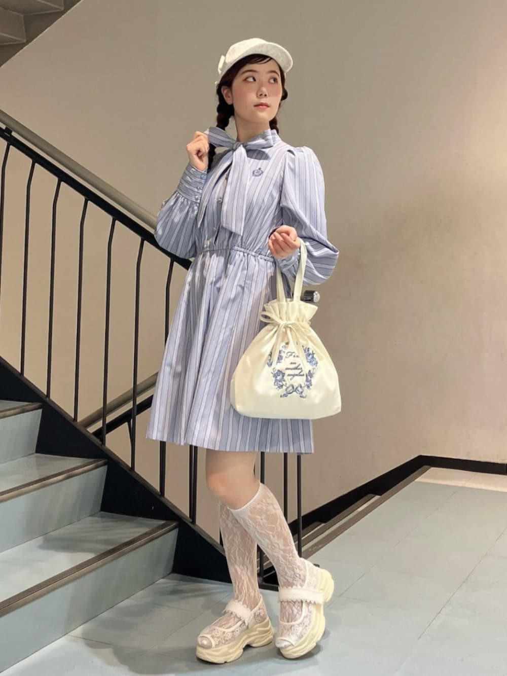 グレー系のワンピース、ホワイト系のサンダル、ホワイト系のキャップを着用したレディースの春コーディネートの2枚目の写真