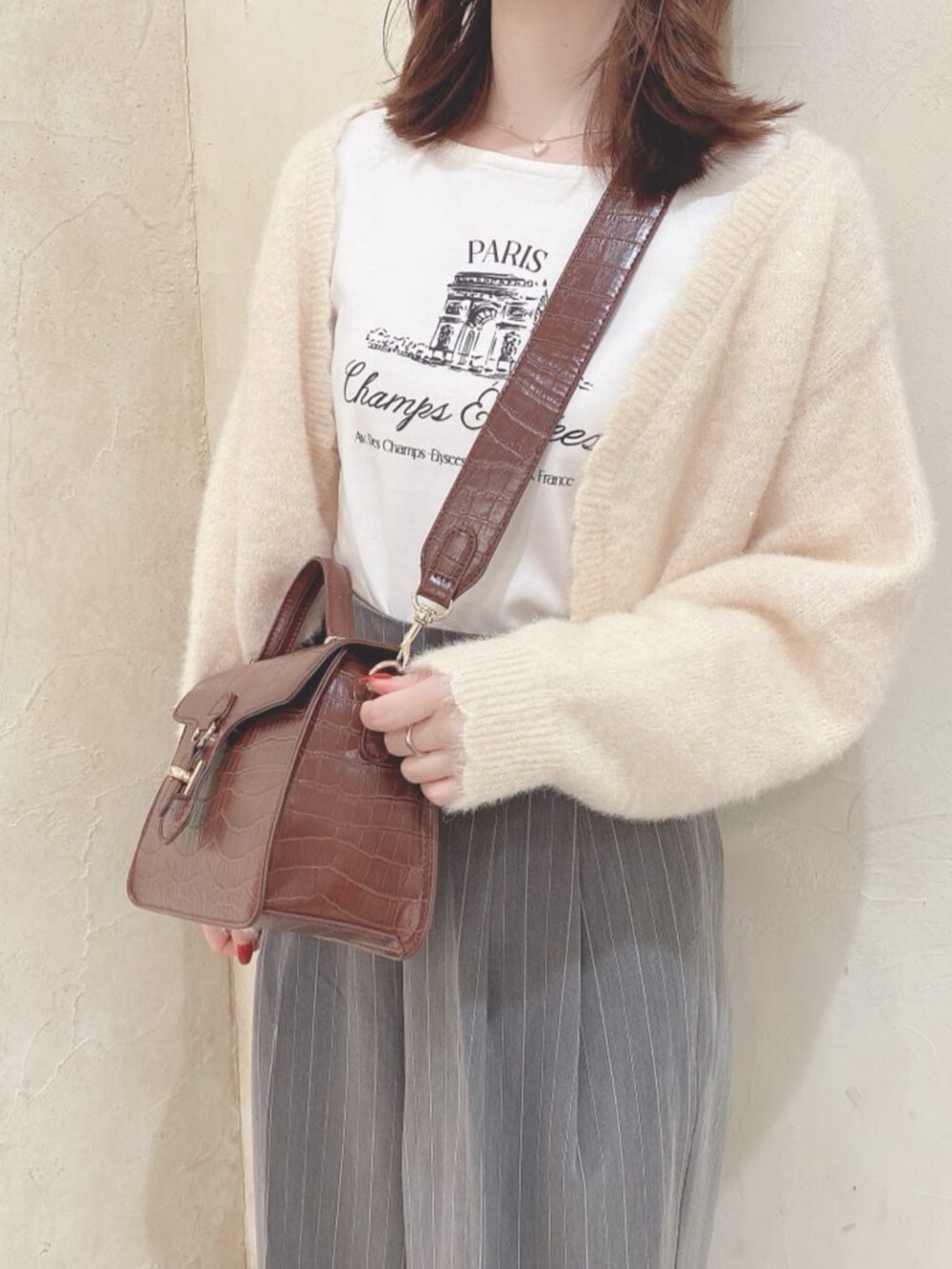 ホワイト系のカーディガン/ボレロ、イエロー系のハンドバッグ、イエロー系のその他シューズを着用したレディースの秋コーディネートの2枚目の写真