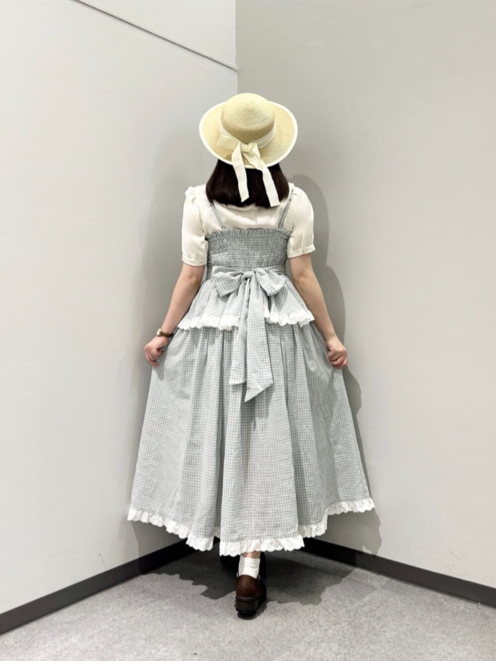 ブラウン系のローファー、ホワイト系のシャツ/ブラウス、グリーン系のワンピースを着用したレディースの春コーディネートの2枚目の写真