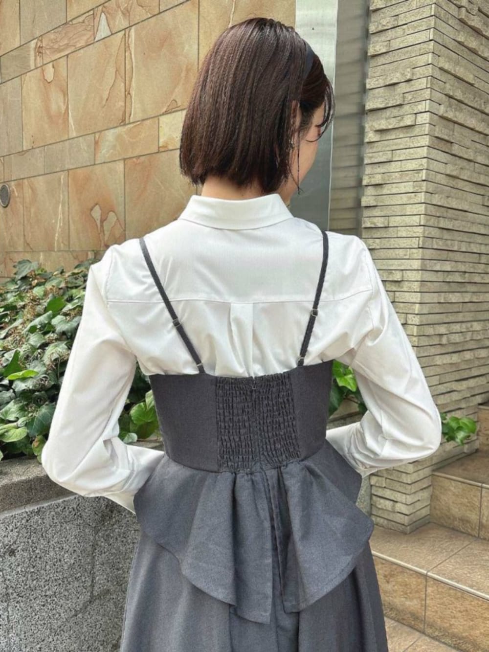 ブラック系のパンプス、グレー系のワンピース、ホワイト系のシャツ/ブラウスを着用したレディースの秋コーディネートの3枚目の写真