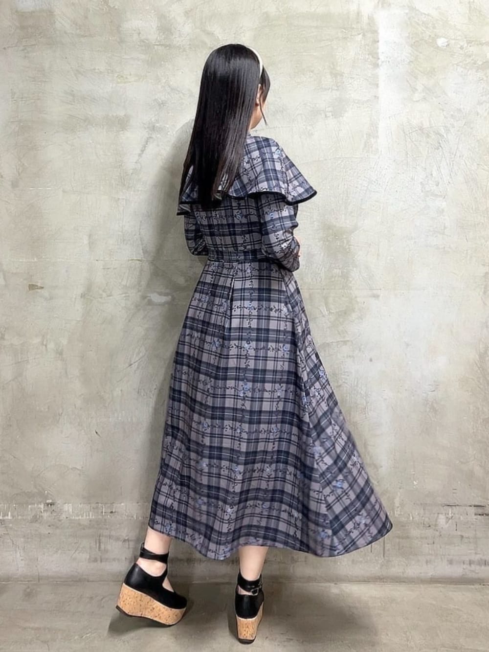 ブラック系のパンプス、ブルー系のワンピースを着用したレディースの秋コーディネートの3枚目の写真