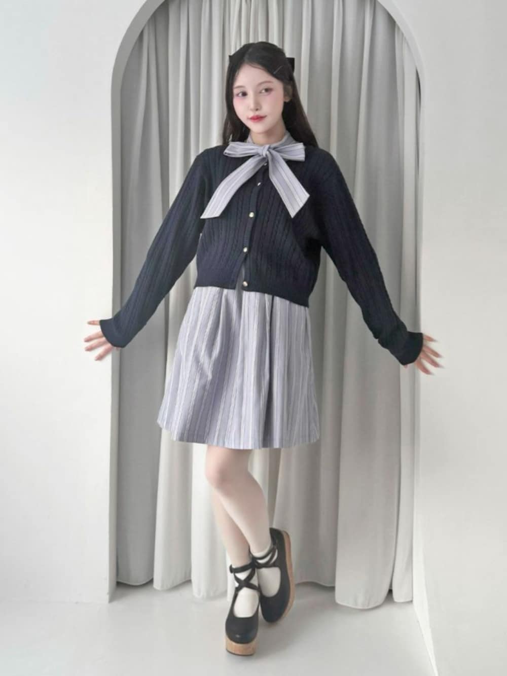 ブラック系のパンプス、ブルー系のカーディガン/ボレロ、ブラウン系のバレッタ/ヘアクリップを着用したレディースの冬コーディネートの3枚目の写真