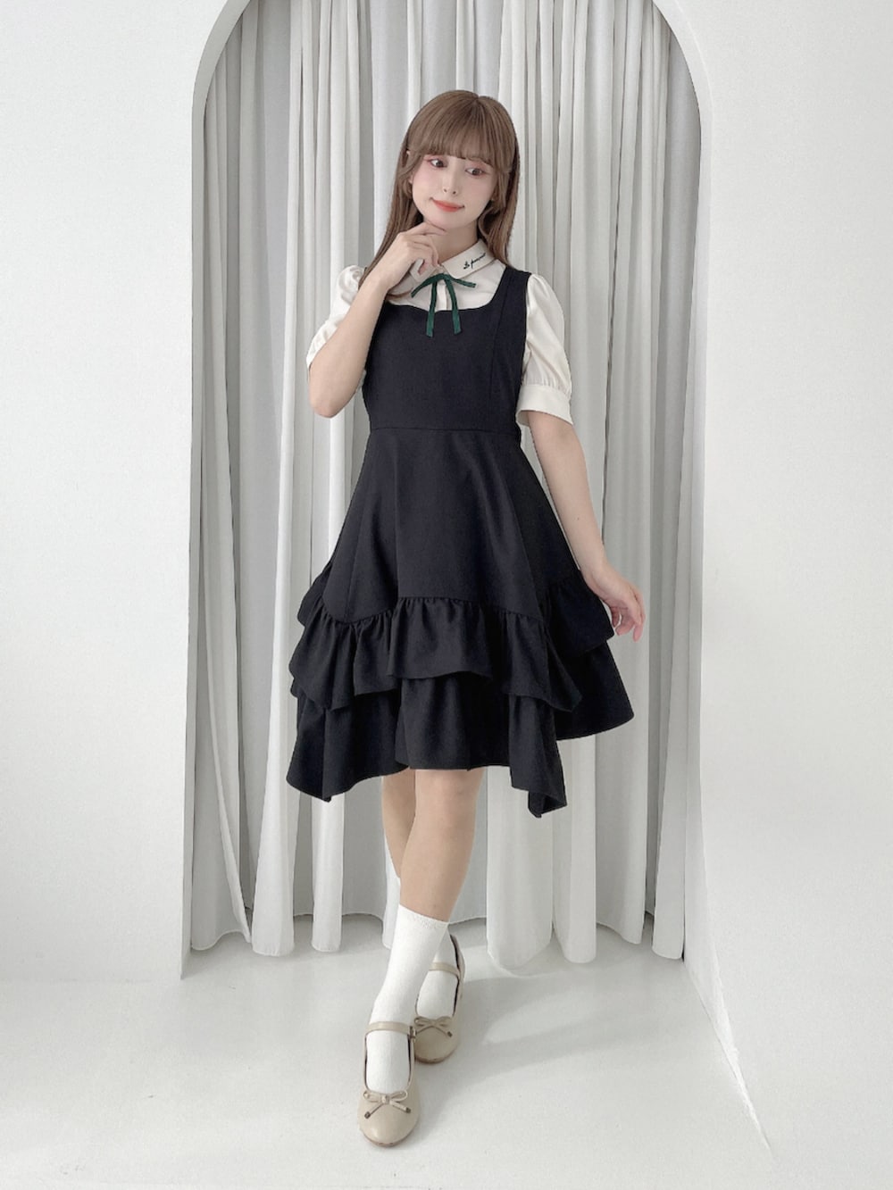 ベージュ系のバレエシューズ、ブラック系のジャンパースカート、ホワイト系のシャツ/ブラウスを着用したレディースの春コーディネートの2枚目の写真